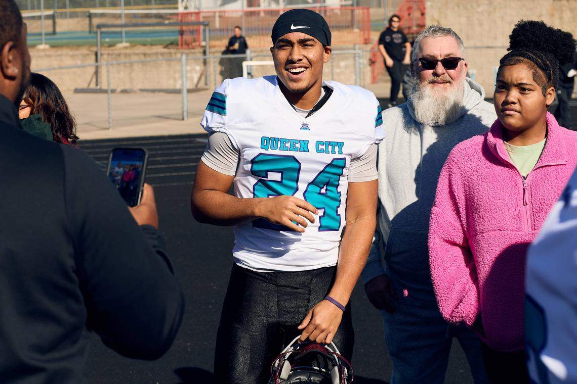 West Mecklenburg DB Marcus Myers (24) celebrates on the track with their family prior to the start of the Queen City Senior Bowl hosted at Olympic High School.