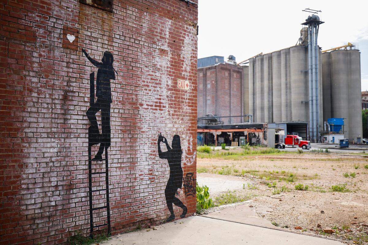 Artwork sits on an abandoned building at the corner of West 9th and Johnson Streets near ADM Milling in Charlotte, June 3, 2022. The lot where the building sits has been rezoned to allow the construction of town homes.