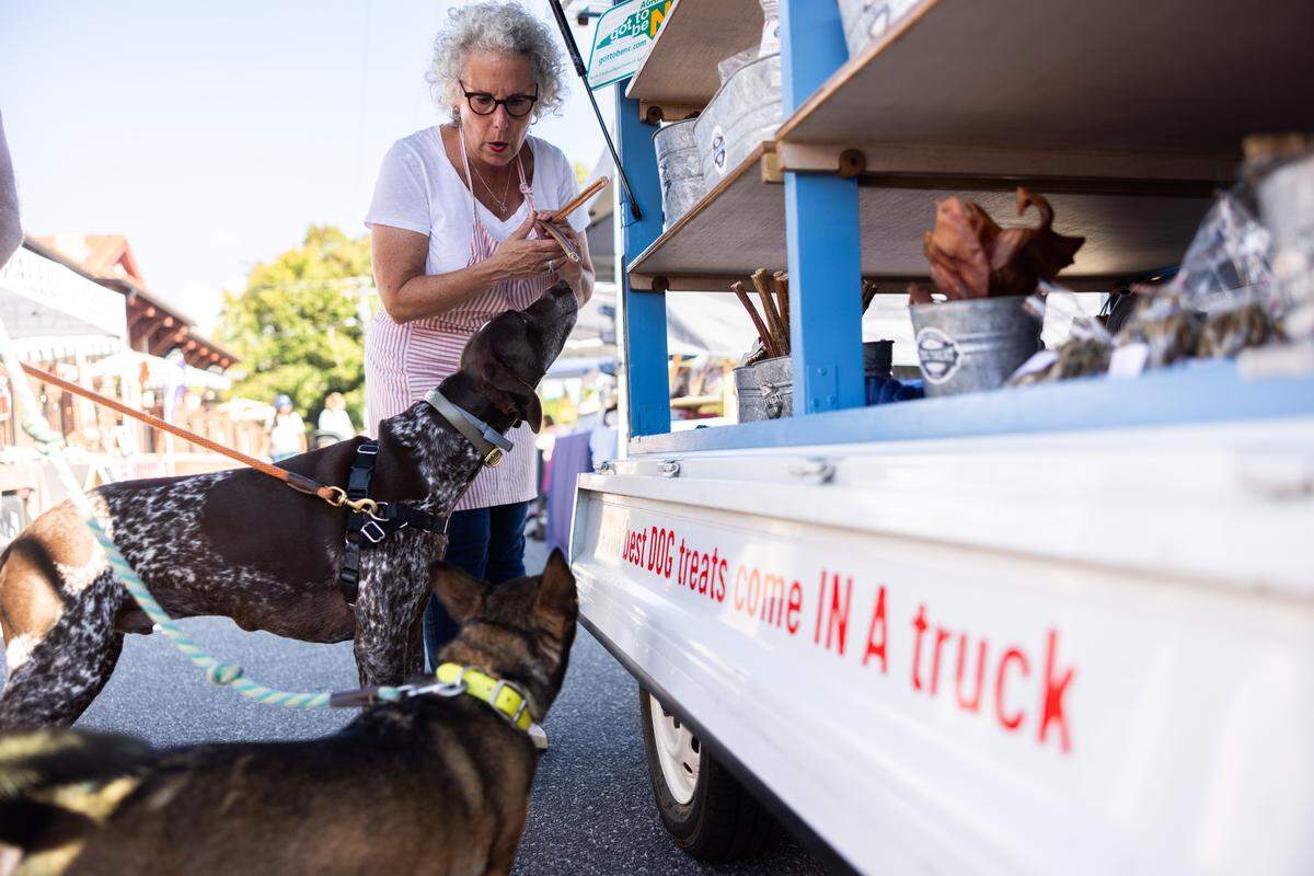 Amy Bossard helps customers pick out treats at her business, Simply American Dog Truck, at the NC Farmers Market in Belmont, N.C., on Monday, September 22, 2025.
