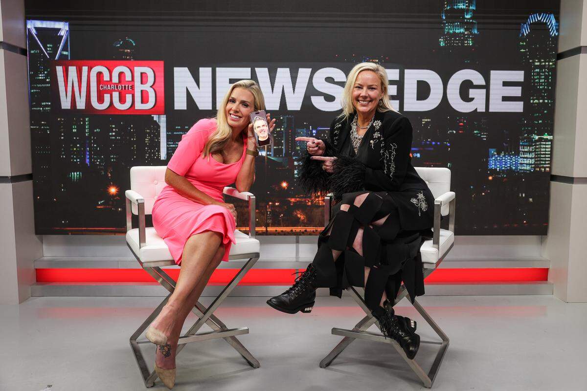 Morgan Fogarty — at left, with a photo of Fred displayed on the screen of her cellphone — and Ashley Anderson, photographed in the WCCB-TV Charlotte studio.