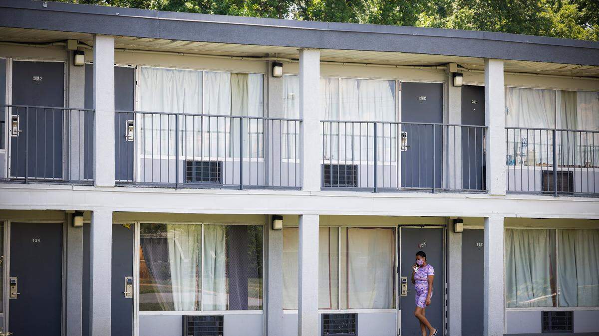 A resident walks along a sidewalk at the Southern Comfort Inn in Charlotte, N.C., Thursday, June 2, 2022. The Southern Comfort Inn is closing at the end of June forcing out roughly 80 residents.