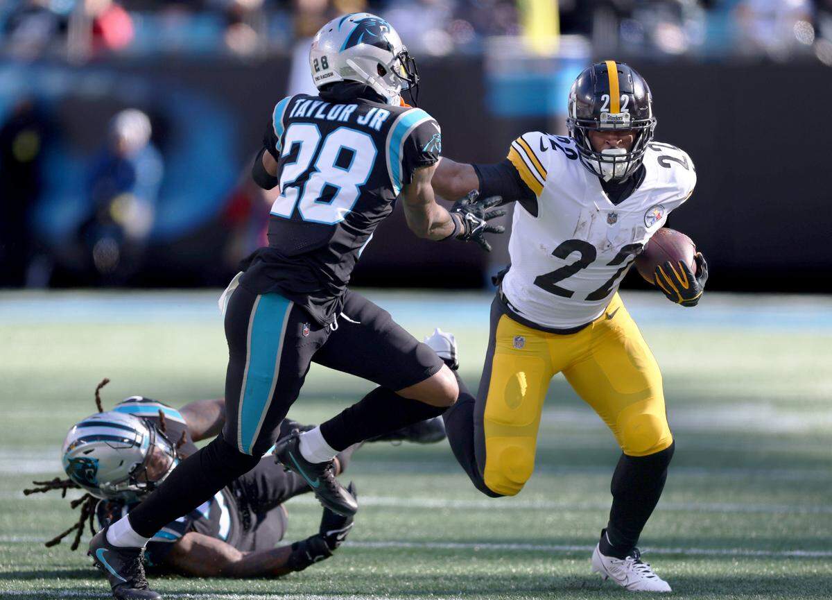 Pittsburgh Steelers running back Najee Harris (22), right, stiff arms Carolina Panthers cornerback Keith Taylor Jr. (28) at the Bank of America Stadium in Charlotte, N.C., on Sunday, December 18, 2022.