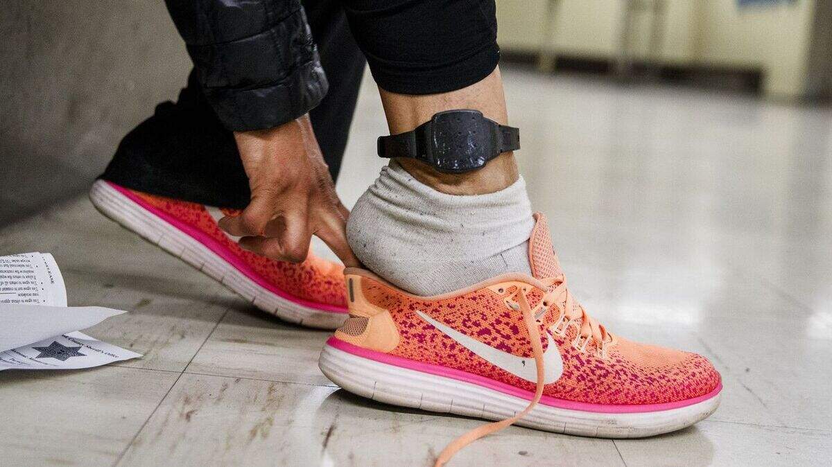 A detainee puts her shoe on after receiving an electronic monitoring device prior to being released from the Cook County Jail in 2018.