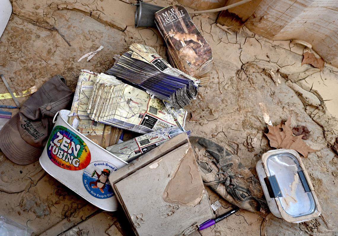 Destroyed tourist maps lay among the caked mud and debris from the floodwaters of Hurricane Helene inside a building at Zen Tubing in Asheville, NC on Wednesday, February 5, 2025.