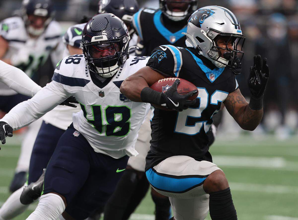 Carolina Panthers running back Trevor Etienne carries the ball as Seattle Seahawks linebacker Tyrice Knight follows during their 2025 game in Charlotte.
