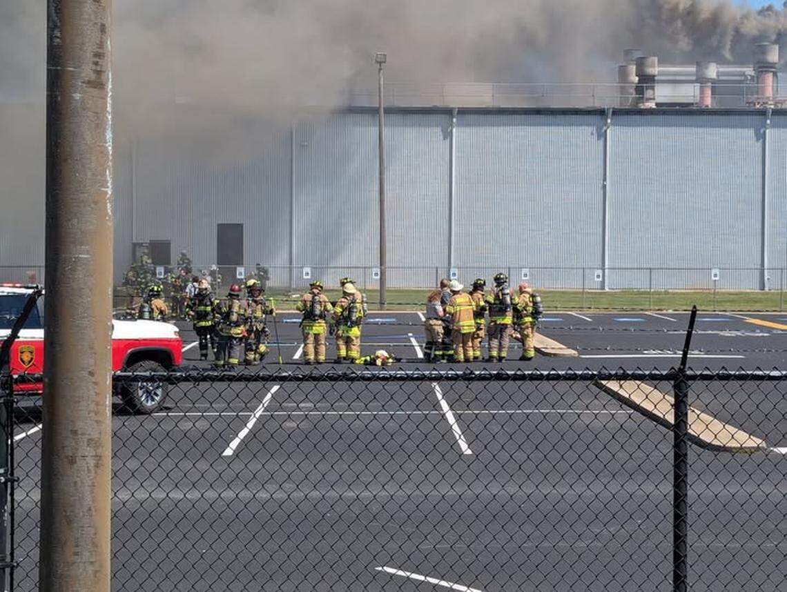 Firefighters gather in the parking lot of the Daimler Truck Freightliner plant in Cleveland, N.C., on Saturday, Aug. 30, 2025. Several firefighters suffered heat exhaustion battling a fire at the massive plant.