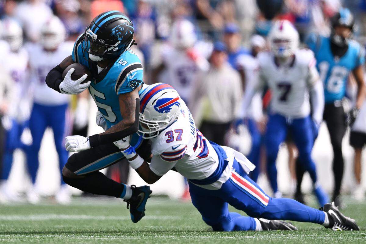 Carolina’s Rico Dowdle is tackled by Buffalo’s Jordan Hancock during Sunday’s game in Charlotte. 