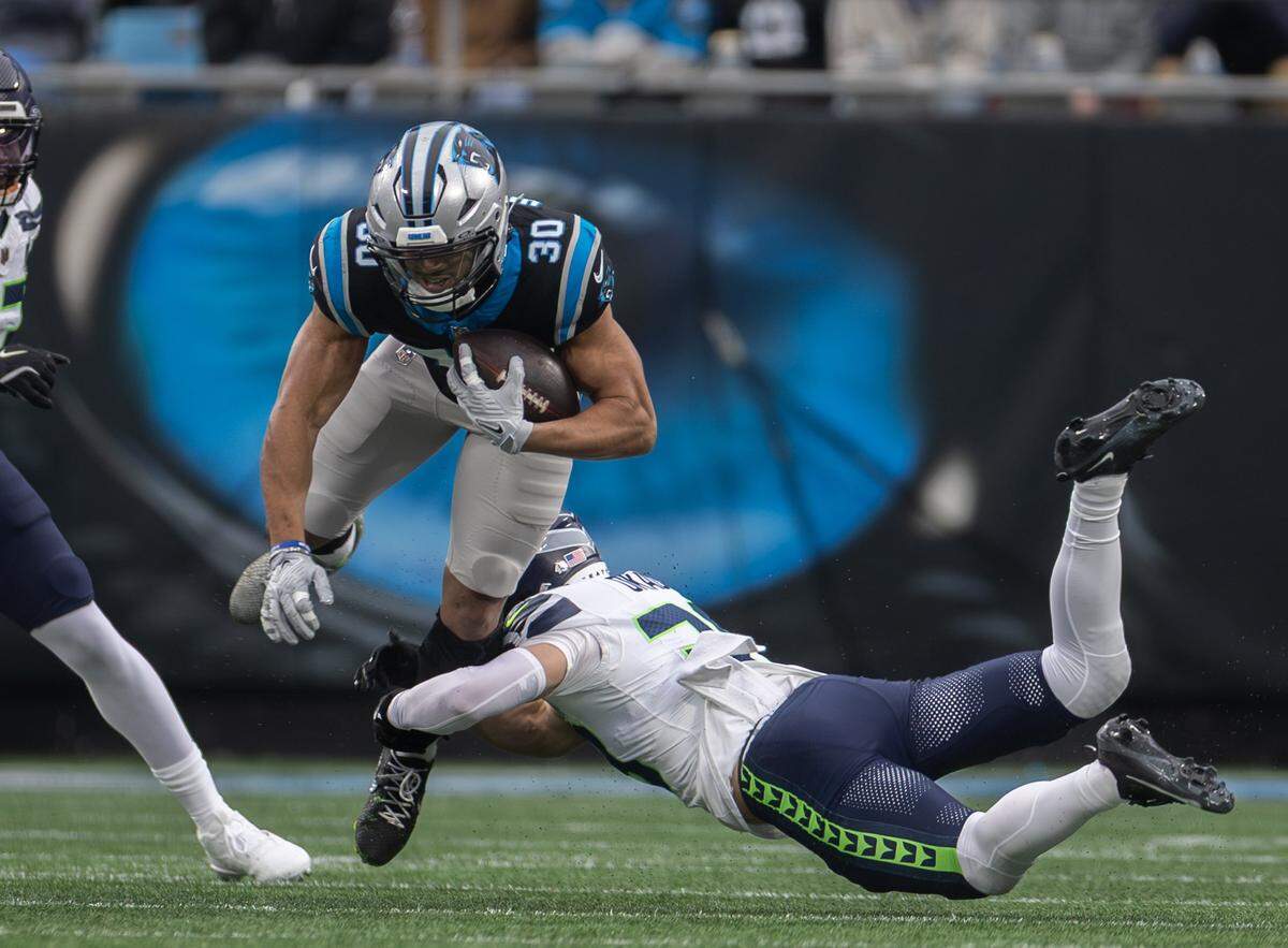 Carolina Panthers running back Chuba Hubbard, top, is tackled by Seattle Seahawks safety Ty Okada at the Bank of America Stadium in Charlotte, N.C., on Sunday, Dec. 28, 2025.