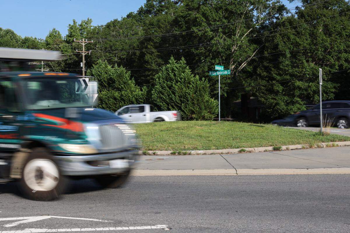 Cars and large trucks use the traffic circle at Mt. Holly-Huntersville Road and Oakdale Road, where construction is underway for a new housing development. Due to an influx of development of housing and shopping centers, the amount of traffic along this this two-lane road has become increasingly congested.