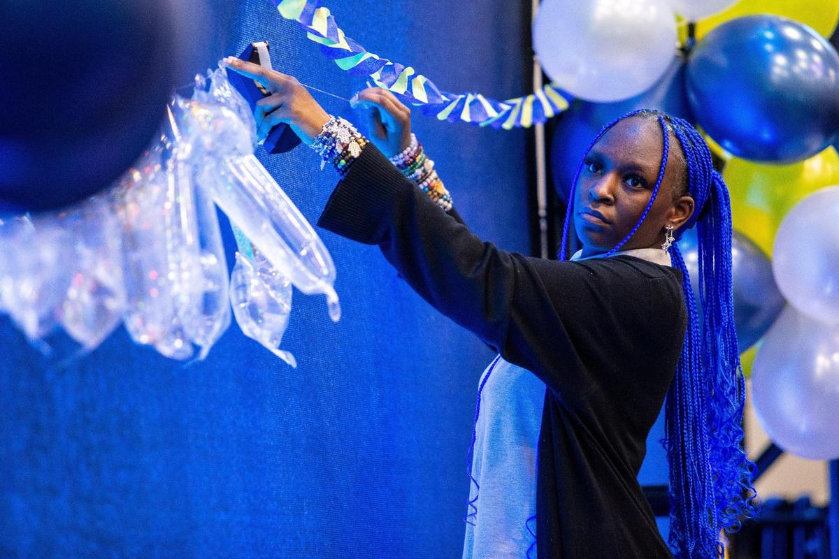 Mounir Chisholm, a senior at Sugar Creek Charter School, helps put up decorations leading up to the surprise announcement of the Charter School Teacher of the Year award in Charlotte, NC on Friday, January 6, 2023. Ryan Henderson was awarded the honor and has been teaching for 11 years.