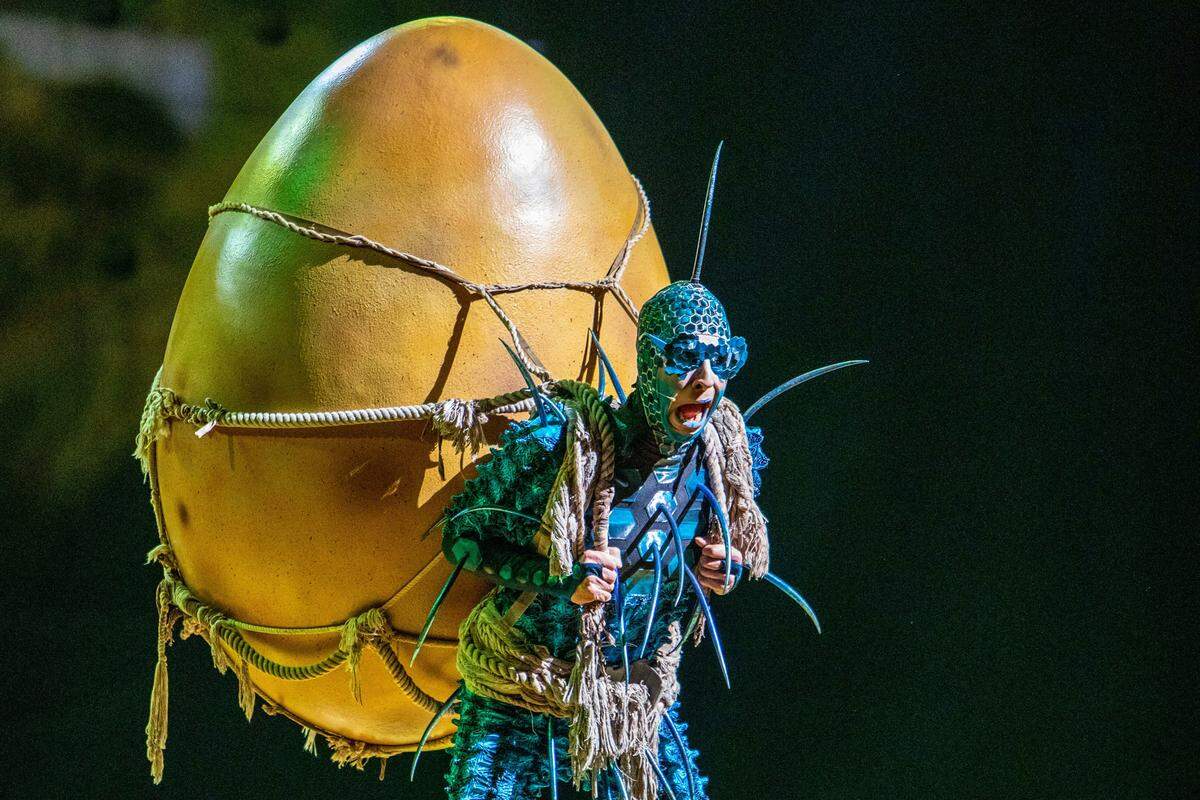 A performer carries the titular egg onto the stage during Cirque du Soleil’s “OVO.”