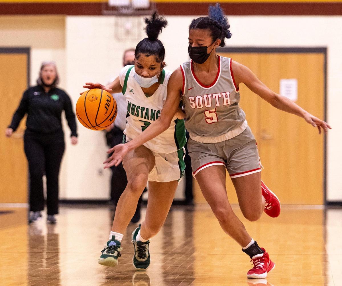 A Myers Park player drives down the court as South Meck’s Anastasia Sinclair tries to stop the drive during the SoMECK conference tournament championship game at Harding High School on Friday, February 18, 2022.