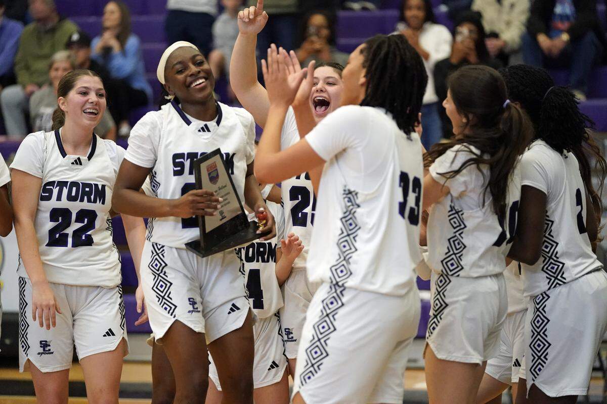 Stuart W. Cramer guard O'Shauna Holland, second from left, celebrates with her teammates after breaking the N.C. High School Athletic Association career scoring record during the second half of the Storm's third-round NCHSAA 4A Western Regional playoff game against Newton's Fred T. Foard High on Feb. 28, 2026, in Belmont, North Carolina. (Bill Kiser/Special to the Charlotte Observer)