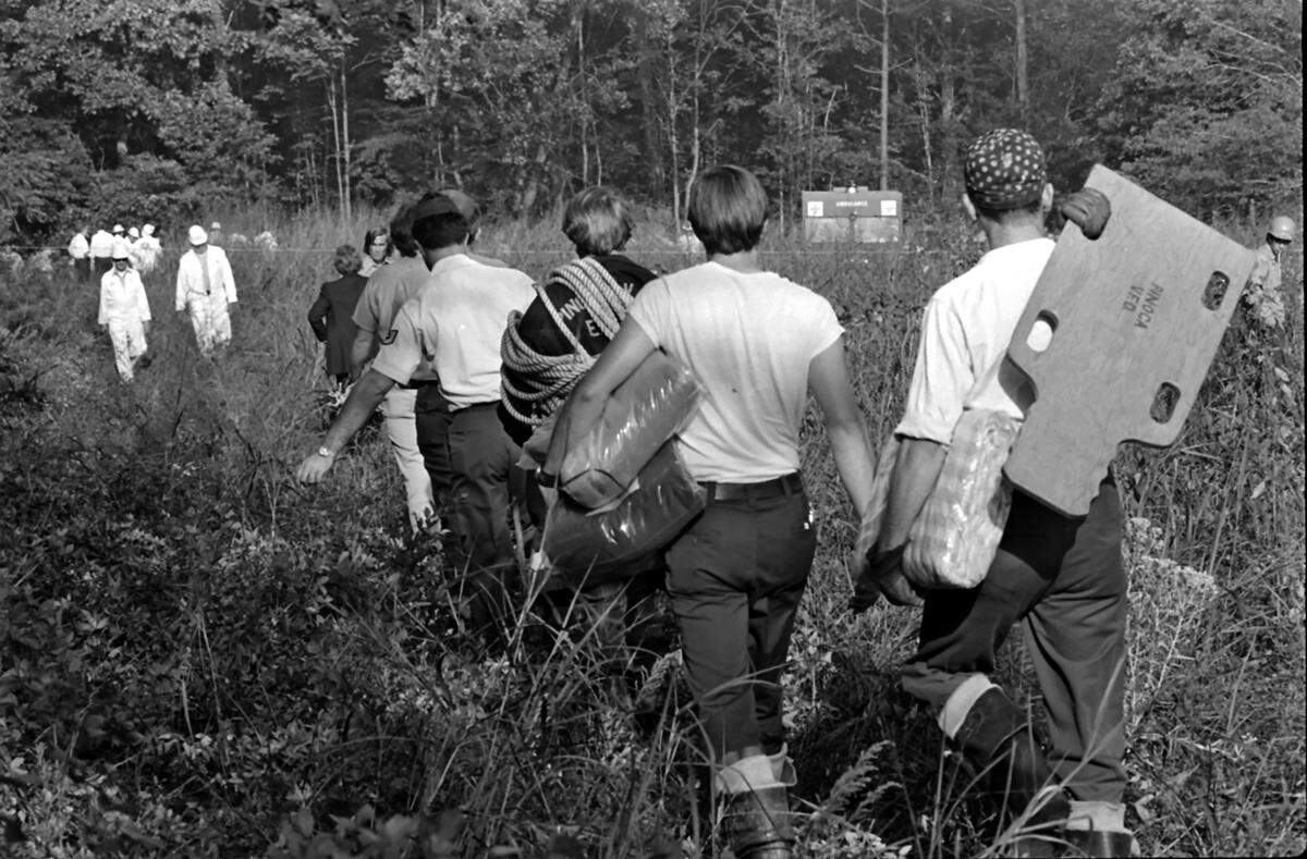 Local rescue workers make their way to the accident scene to carry away the injured and the deceased in Charlotte in the aftermath of the crash of Flight 212.