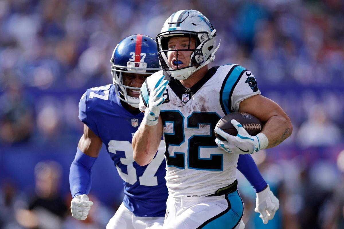 Carolina Panthers running back Christian McCaffrey (22) runs with the ball past New York Giants defensive back Fabian Moreau (37) during an NFL football game Sunday, Sept. 18, 2022, in East Rutherford, N.J. (AP Photo/Adam Hunger)
