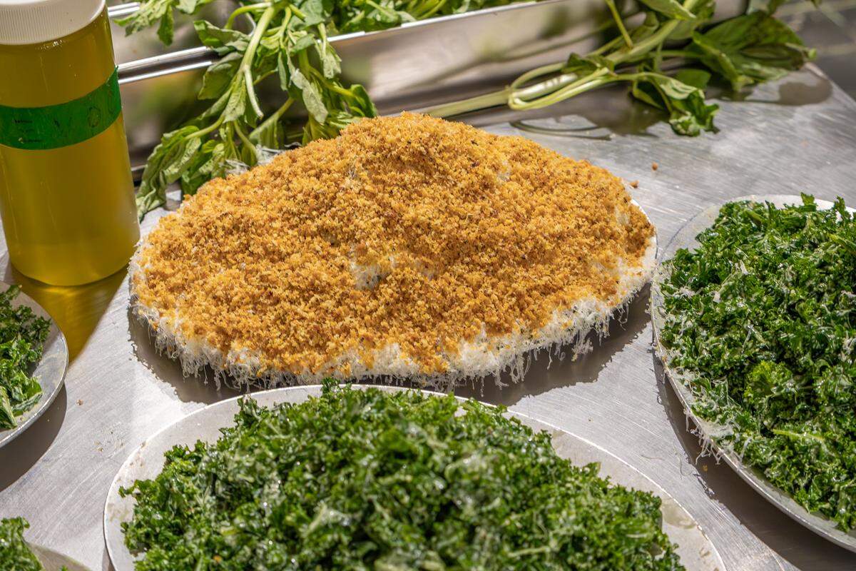 The kale salad at Bird Pizzeria overflows the plate with massaged kale, house dressing, freshly grated Grana Padano cheese and house-made crouton crumbs.