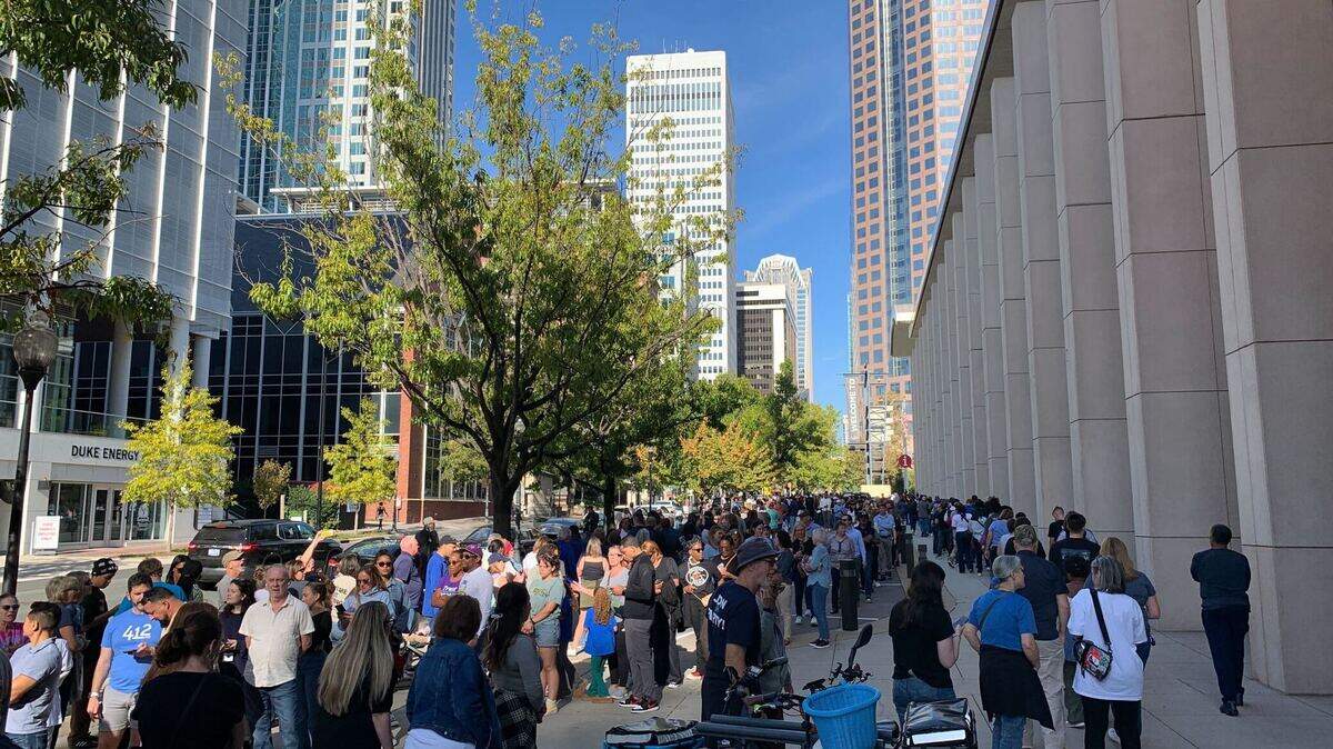 Lines of people stretch down S. College Street outside the Charlotte Convention Center, where former President Barack Obama will rally support for the Harris-Walz campaign.