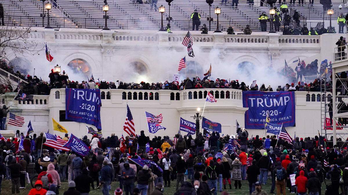 FILE - Violent insurrectionists loyal to President Donald Trump storm the Capitol, Jan. 6, 2021, in Washington. An Ohio man charged with stealing a coat rack from the U.S. Capitol doesn’t deny that he joined the mob that stormed the building last year. But a lawyer for Capitol riot defendant Dustin Thompson vows to show that former President Donald Trump abused his power to authorize the attack on Jan. 6. (AP Photo/John Minchillo, File)
