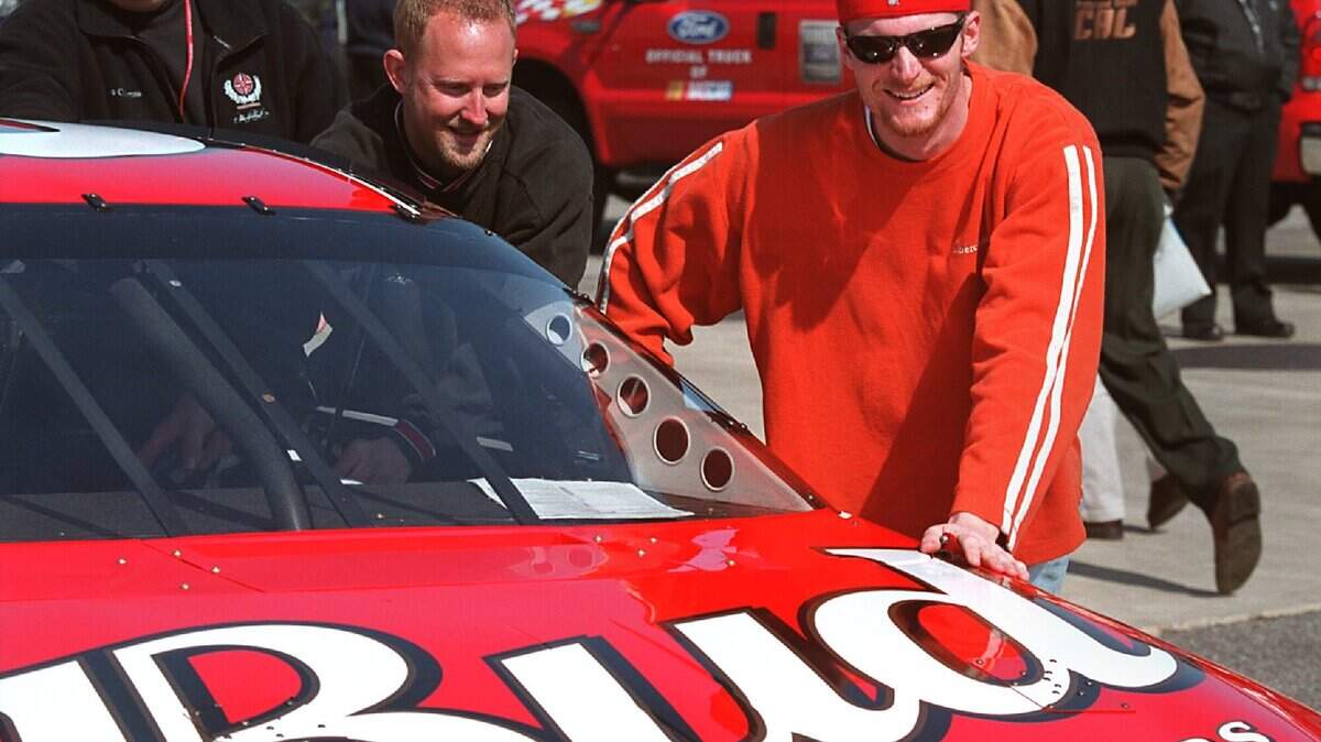In this Charlotte Observer file photo from 2001, Dale Earnhardt Jr. smiles as he and members of his Chevrolet Budweiser No. 8 team filled the car with gas and pushed it into position to be inspected in the Cup series garage area at North Carolina Speedway near Rockingham