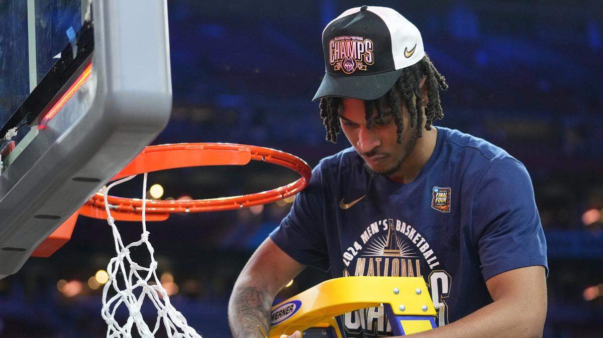 Connecticut Huskies guard Stephon Castle (5) cuts the basketball net after winning the Men's NCAA national championship game against the Purdue Boilermakers at State Farm Stadium in Glendale.