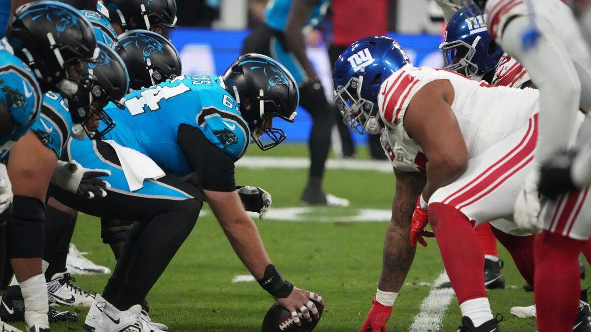 Nov 10, 2024; Munich, Germany; Carolina Panthers center Cade Mays (64) snaps the ball against the New York Giants in the first half during the 2024 NFL Munich Game at Allianz Arena. Mandatory Credit: Kirby Lee-Imagn Images