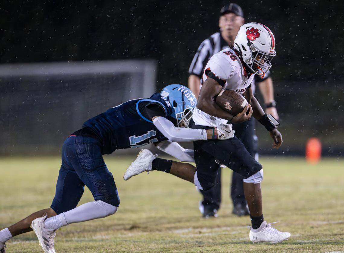 South Mecklenburg Sabres Raivon Pauling, right, is tackled by Hopewell Titans Calvin Johnson at Hopewell High School in Huntersville, N.C., on Friday, September 26, 2025.