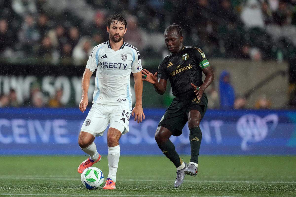 Luca de la Torre, left, of San Diego FC passes the ball under pressure from Diego Chara of the Portland Timbers during the first half at Providence Park on Oct. 18, 2025 in Portland, Oregon.