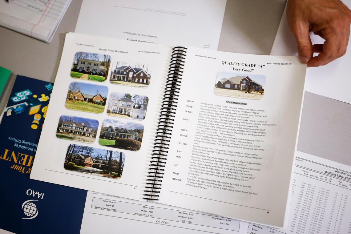 Brad Fowler shows pages in the county appraiser’s field guide at the Mecklenburg County Assessor’s Office. Fowler says the mass appraisal process does not happen with the push of a button, but requires field visits and analytical work.