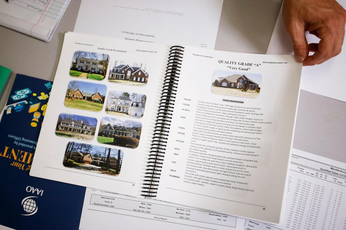 Brad Fowler shows pages in the county appraiser’s field guide at the Mecklenburg County Assessor’s Office. Fowler says the mass appraisal process does not happen with the push of a button, but requires field visits and analytical work.