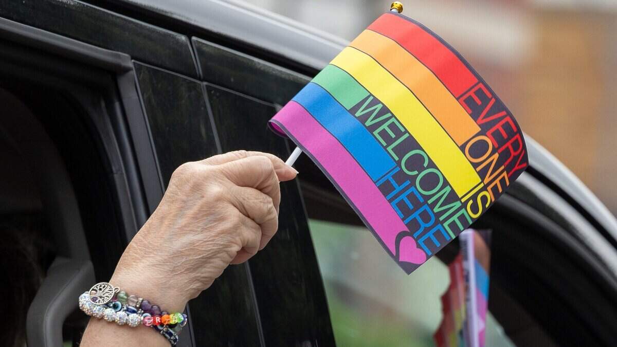 A parade attendee holds a flag out the window of their car during Kansas City’s Annual Pride Parade on June 6, 2026.