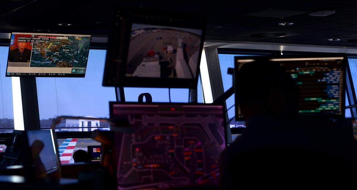 Weather (upper left) is one of many things monitored by workers at the American Airlines Hub Control Center at Charlotte Douglas International Airport.