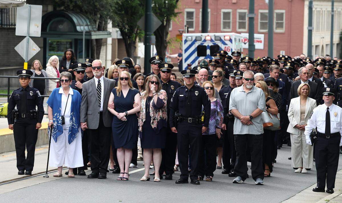 The family of slain Charlotte-Mecklenburg Police Officer Joshua Eyer and police officers prepare to walk from the Fallen Officer Memorial Statue to First Baptist Church in uptown Charlotte, NC on Friday, May 17, 2024. CMPD Chief Johnny Jennings unveiled Eyer’s engraved name on the monument during a ceremony. Eyer died from wounds sustained during a gun battle on Monday, April 29, 2024.