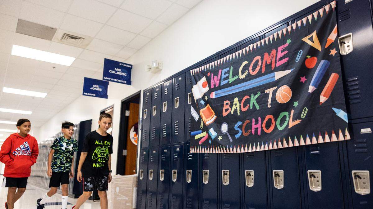 Students walk past a sign that says Welcome Back to School during the first day of school at Lake Norman Charter Middle School in Huntersville, N.C., on Thursday, August 10, 2023.