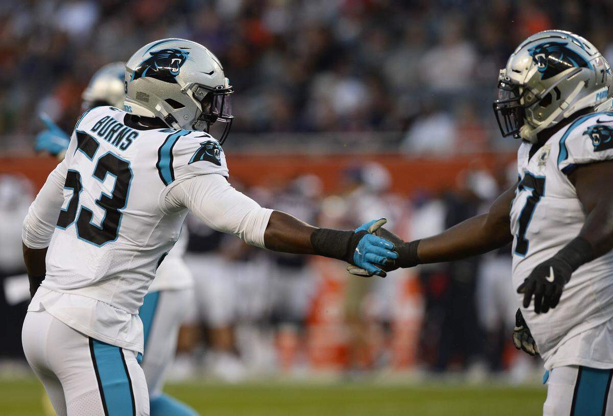 Carolina Panthers defensive end Brian Burns (53) and defensive tackle Kyle Love (77) celebrate Burns’ sack against the Chicago Bears in the first quarter Thursday.