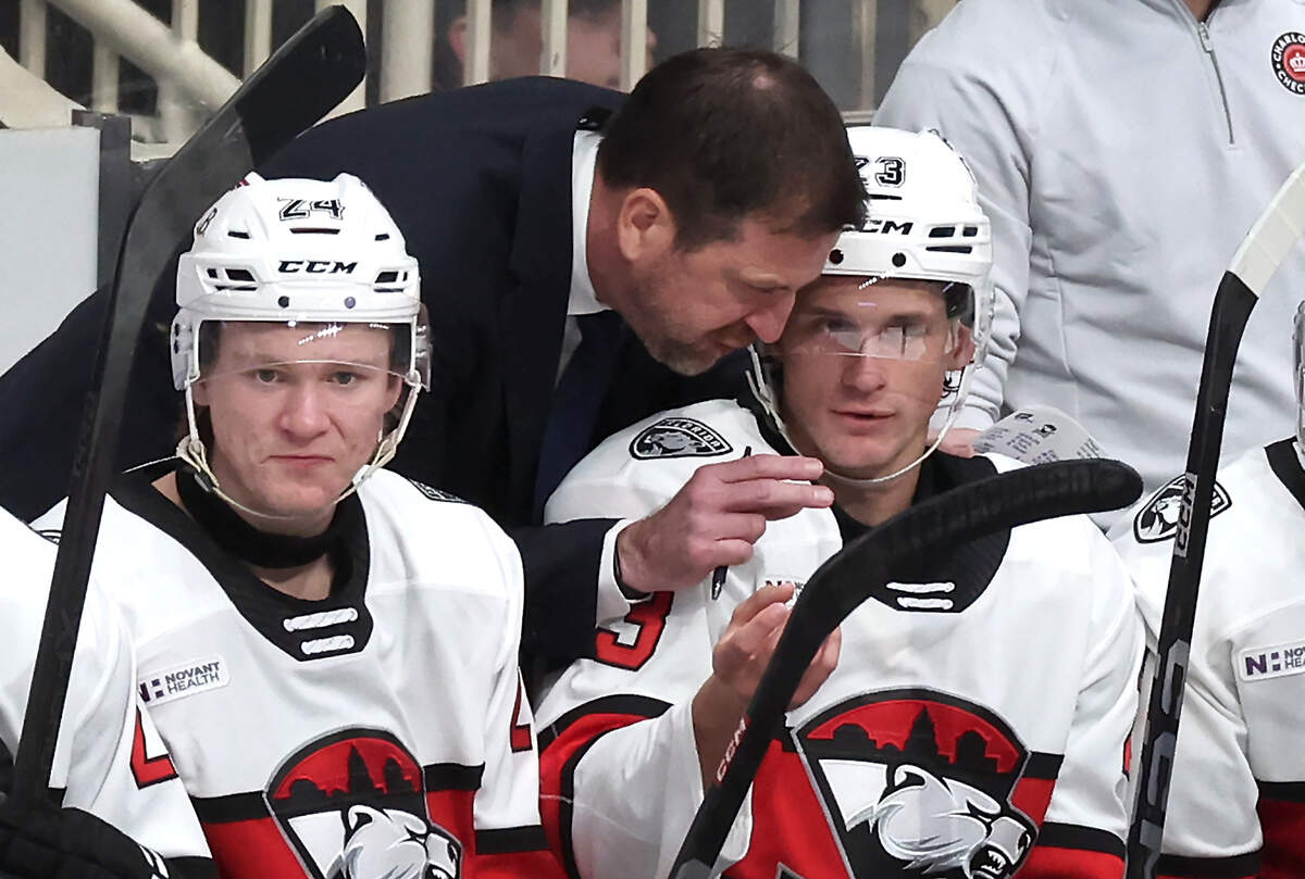 Charlotte Checkers head coach Geordie Kinnear, center, speaks with forward Jack Studnicka, right, following a series against the Iowa Wild on Friday, October 17, 2025 at Bojangles Coliseum in Charlotte, NC.