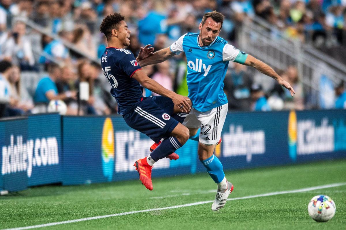 New England Revolution’s Brandon Bye, left, is pushed by Charlotte FC’s Christian Fuchs, during the game against New England at Bank of America Stadium on Saturday, March 19, 2022 in Charlotte, NC.