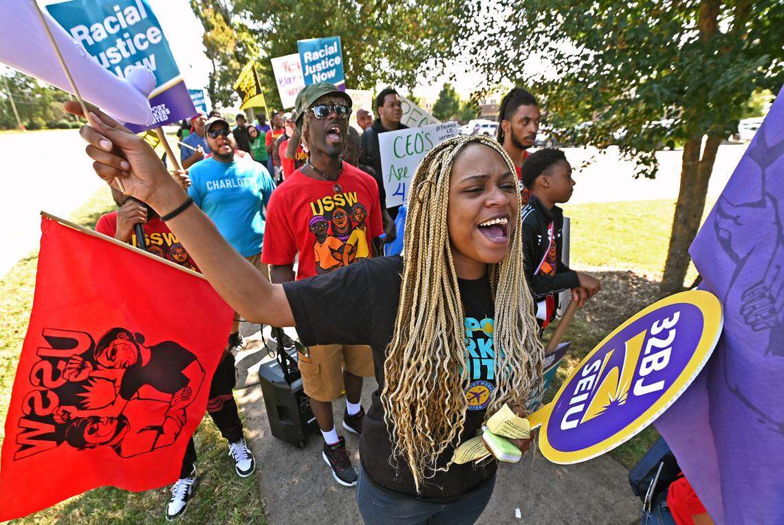 Jessica McQuaig, an employee at Walmart, joins airline workers Tuesday as they rally along Wilkinson Boulevard in Charlotte.