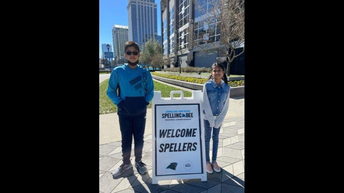 Rishi and Harini Jayakumar pose for a photo at a regional spelling bee hosted in March by the Carolina Panthers.