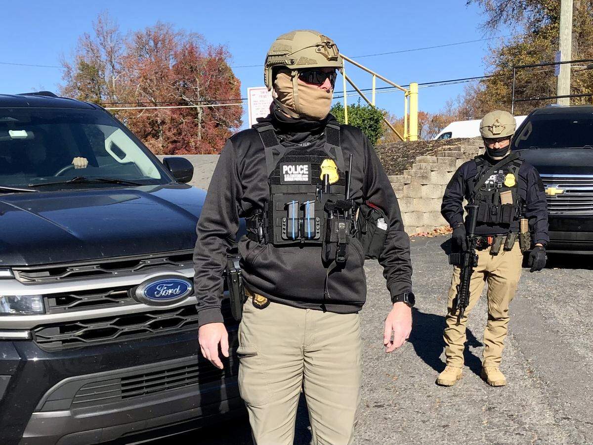 U.S. Customs and Border Patrol agents survey the parking lot of the Compare Foods on North Tryon St. in Charlotte, NC on Monday, November 17, 2025. 