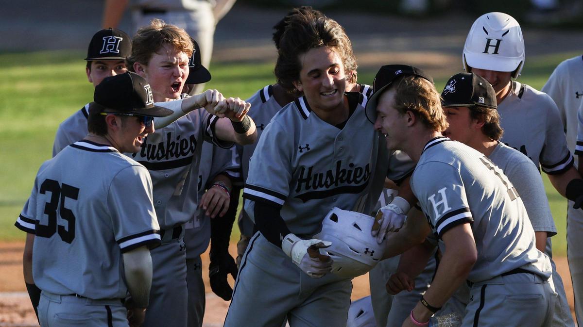 Hough’s Jaxon Matthews, center, celebrates with teammates after hitting a home run on Tuesday, May 9, 2023 during the first round of the first round of the NCHSAA 4A baseball playoffs at Myers Park High School.