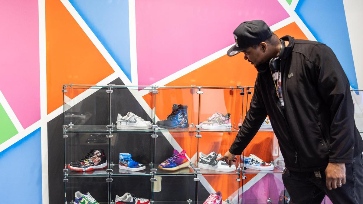 Danyell Butler, co-owner of Modified Kicks, shows a display of some sneakers at Modified Kicks in Northlake Mall in Charlotte.