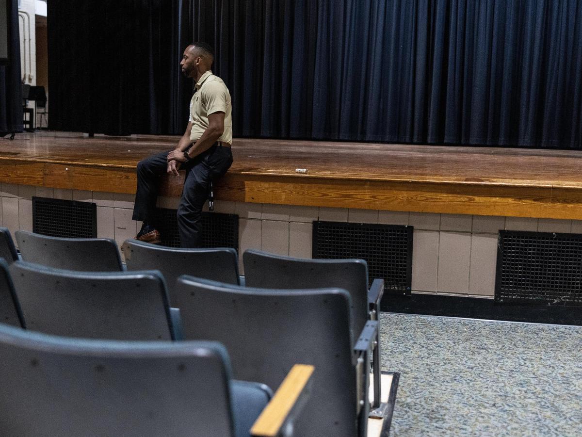 Principal Glenn L. Starnes sits on the stage in the auditorium at Harding University High School in Charlotte, N.C., on Wednesday, October 5, 2023.