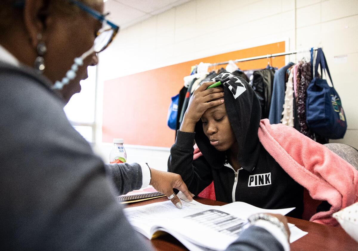 Camille Stephens, left, helps Mekayla Rodgers, 18, fill out a workbook at The Mecklenburg Council of Elders Juvenile Diversion program in Charlotte, N.C., on Tuesday, March 30, 2022.