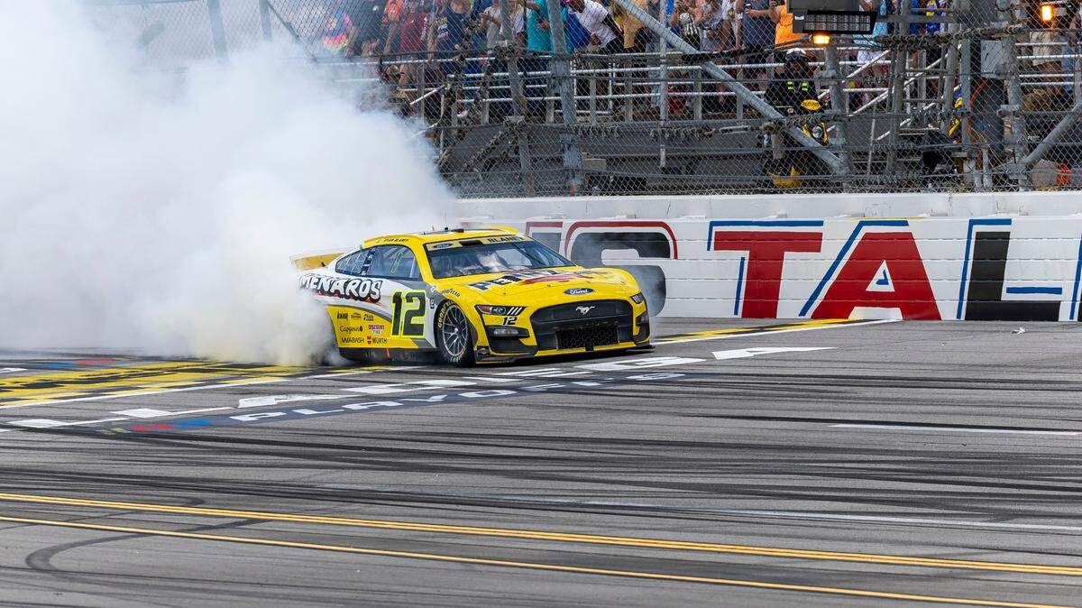 Oct 1, 2023; Talladega, Alabama, USA; NASCAR Cup Series driver Ryan Blaney (12) burns out on the track after his victory at the 2023 YellaWood 500 at Talladega Superspeedway. Mandatory Credit: Vasha Hunt-USA TODAY Sports