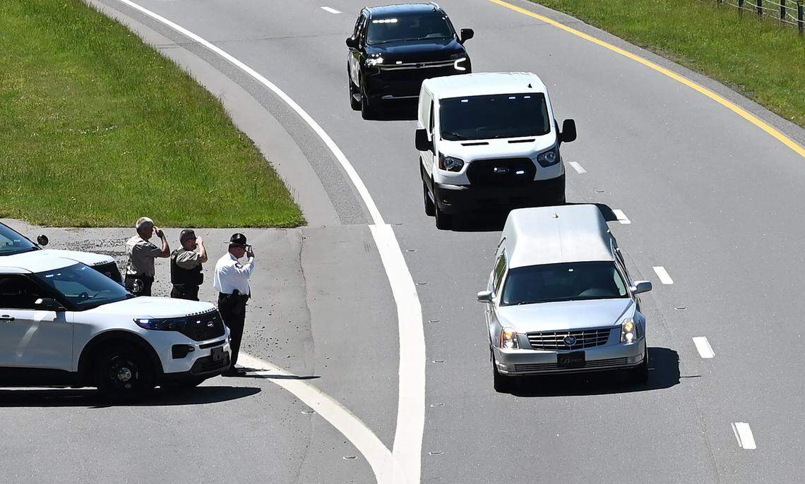 Officers stand at attention saluting the hearse carrying the body of slain officer Alden Elliott along N.C. 16 on Thursday, May 2, 2024. The procession traveled from Charlotte to Newton, NC. Elliott, a 14-year officer with the North Carolina Department of Adult Correction, was among the four officers killed and four wounded while serving a warrant in east Charlotte on Monday, April 29th, 2024.