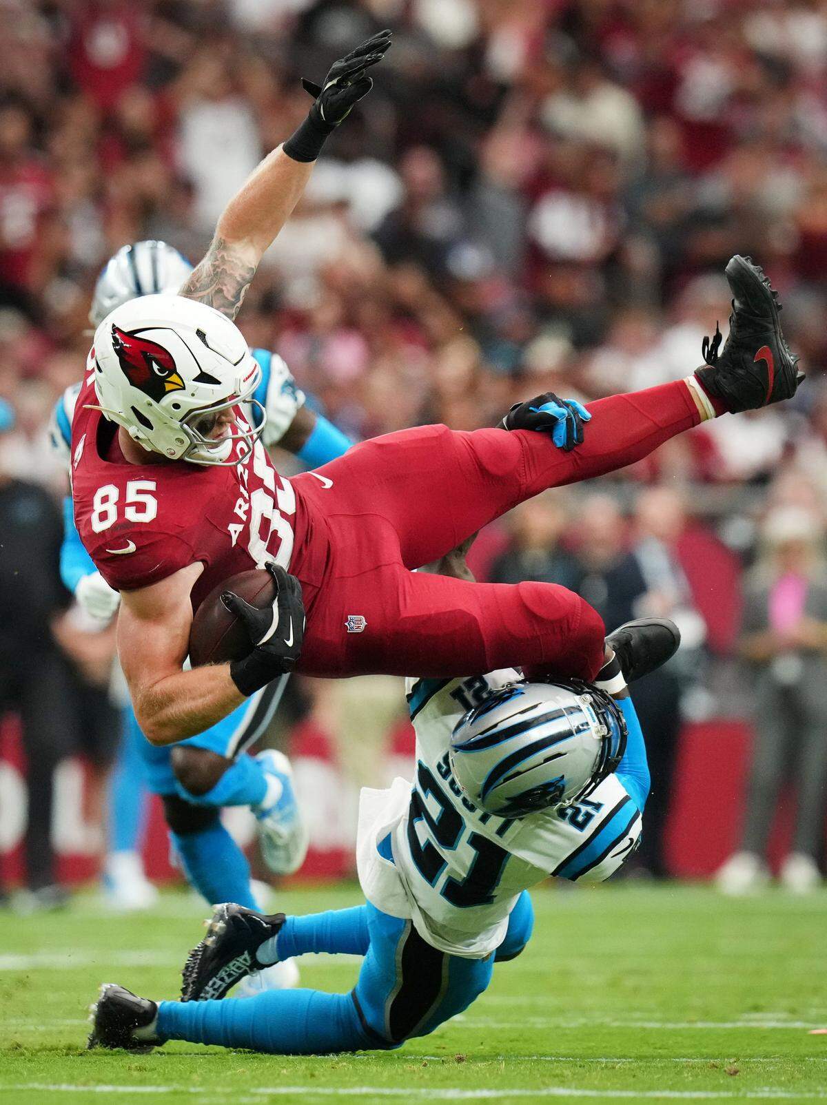Arizona Cardinals tight end Trey McBride (85) is tackled by Carolina Panthers safety Nick Scott (21) after making a first-down catch at State Farm Stadium on Sept 14, 2025.