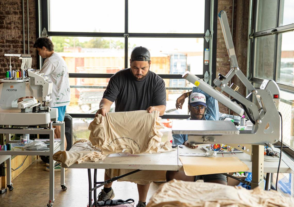 Mason Thomas, left, Anthony Colón, center, and Hasam Dirton work on their projects at MacFly Printing Co. at Camp North End in Charlotte, on Wednesday, June 9, 2021. U.S. Senate hopeful Cheri Beasley stopped by as she campaigned in Charlotte.