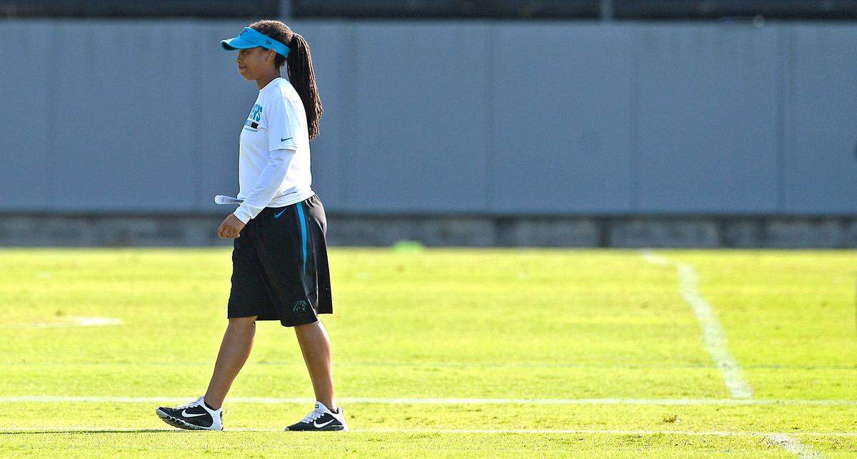 Carolina Panthers coaching intern Jennifer King walks downfield before the team's minicamp practice on Wednesday. King is the women's head basketball coach at Johnson and Wales University in Charlotte, NC, and most days works from 7 a.m.-midnight to remain prepared for her duties.