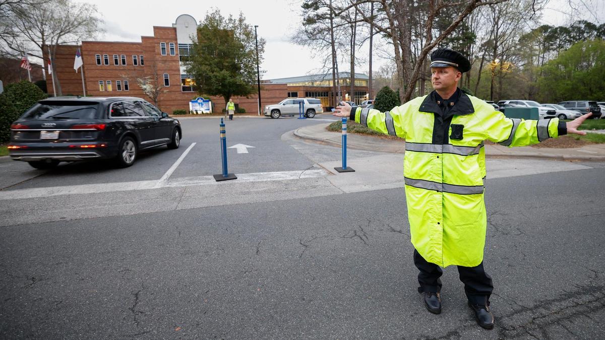 Charlotte-Mecklenburg Police Capt. Ryan Jackson directs traffic along Sardis Road in front of Charlotte Christian School in Charlotte, N.C., Thursday, March 31, 2022.