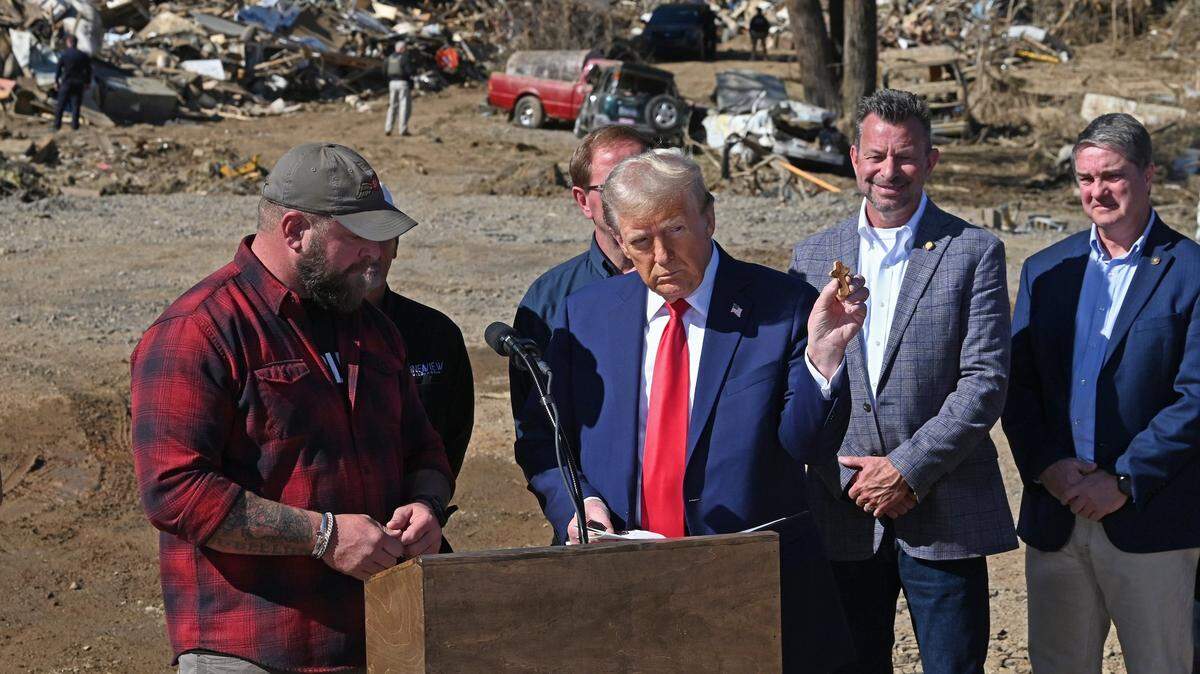 Adam Smith, left, a former Green Beret presents former President Donald J. Trump, right, with a cross memento during the former president’s tour of damage caused in Swannanoa, NC area by Hurricane Helene on Monday, October 21, 2024.